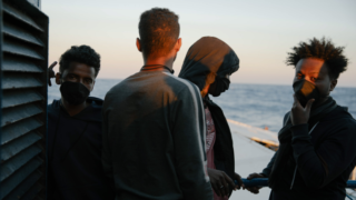 Migranti čekají, až je úřady vpustí na pevninu.