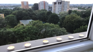 Lidé zapalují svíčky za oběti tragické události.