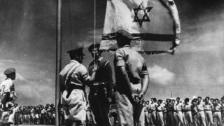 Vyvěšení izraelské státní vlajky ve vojenském táboře - červen 1948