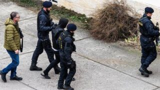 Eskorta přívádí k vazebnímu řízení u Okresního soudu mladíka obviněného z vraždy dvou žen